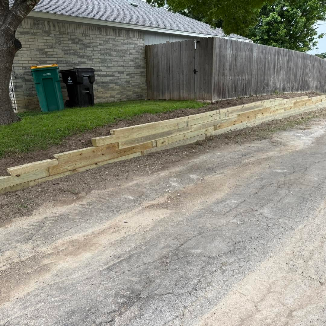 Heavy-duty timber retaining wall installation by landscapers in Temple TX